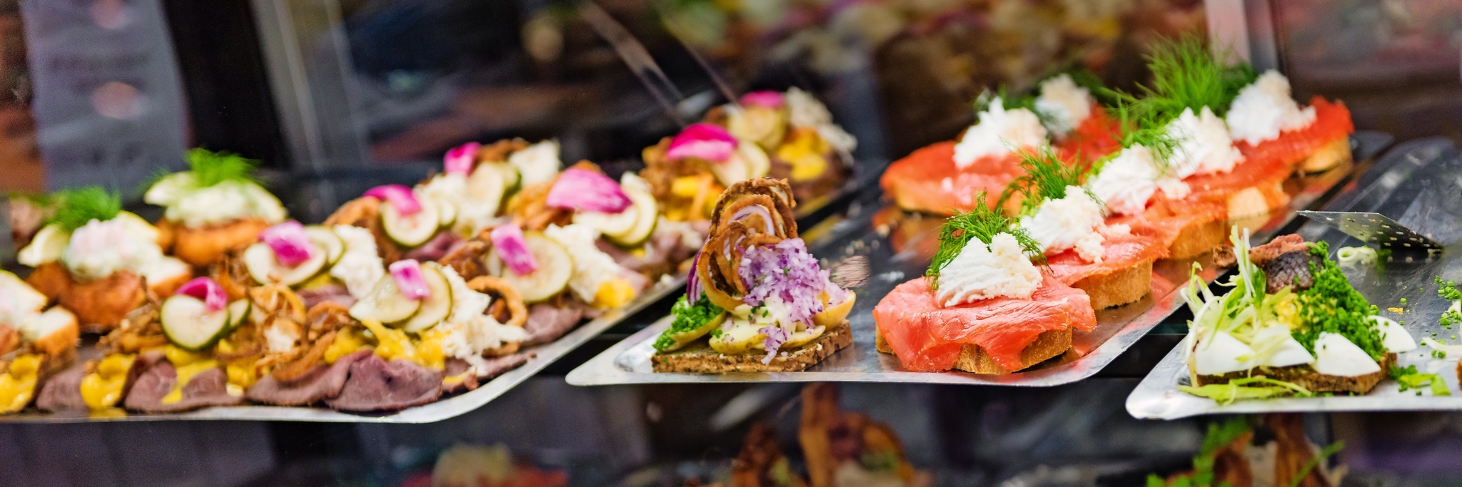 Auslage mit verschiedenen Canapés, darunter Lachs und Gemüse.