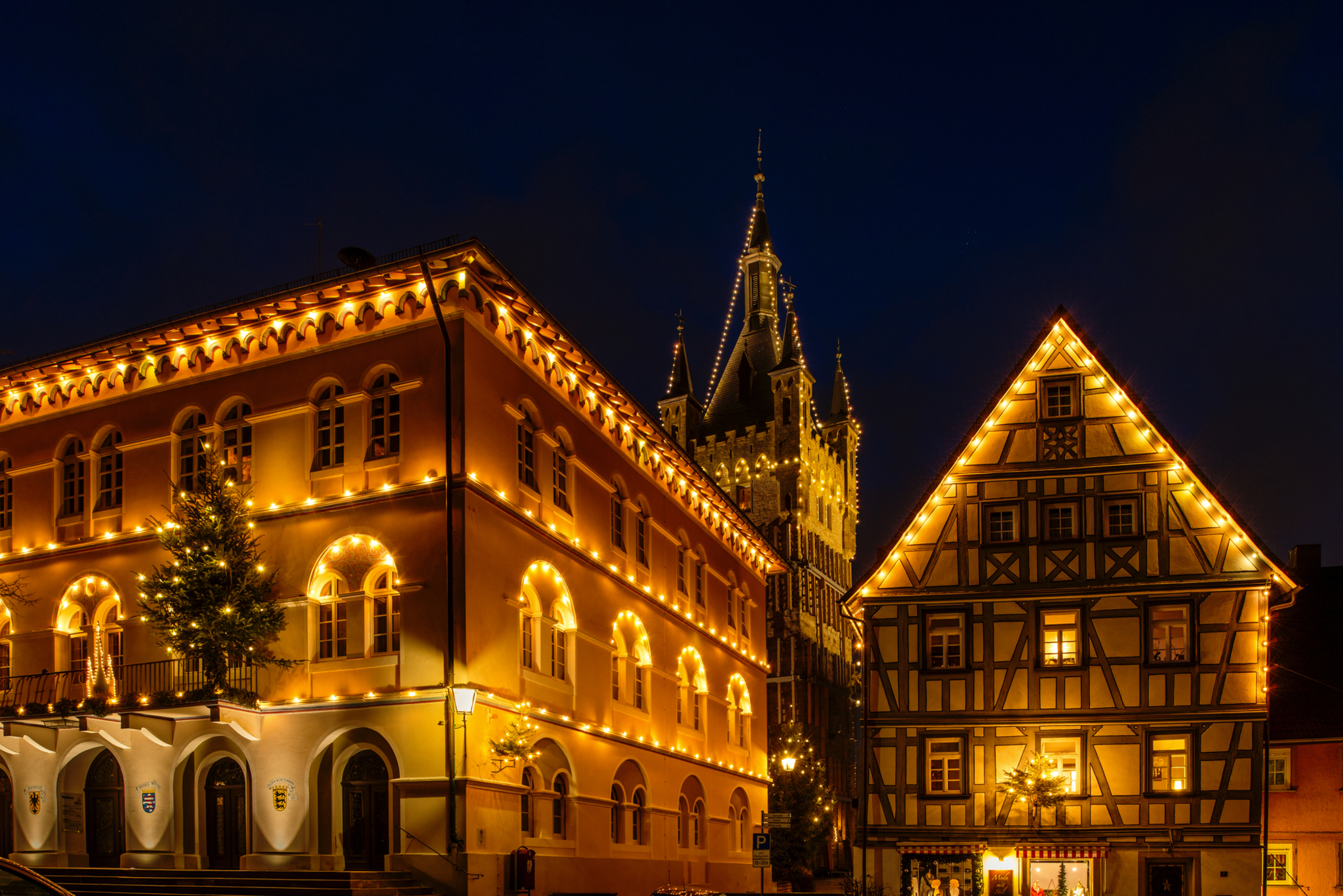 Beleuchtete historische Gebäude in einer Stadt bei Nacht.